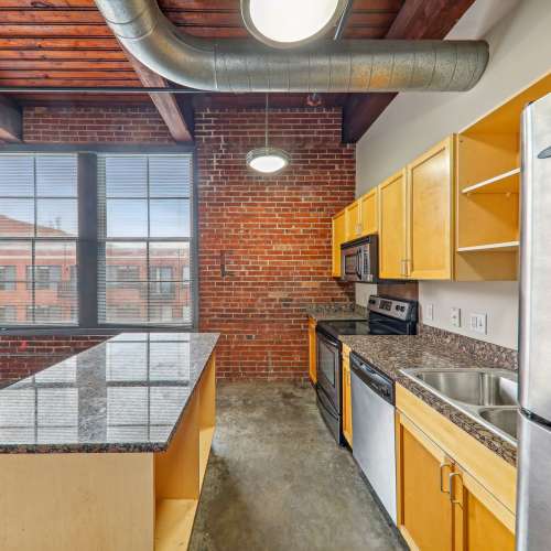 Kitchen with island countertop at Stadium Loft Apartments in Saint Louis, Missouri