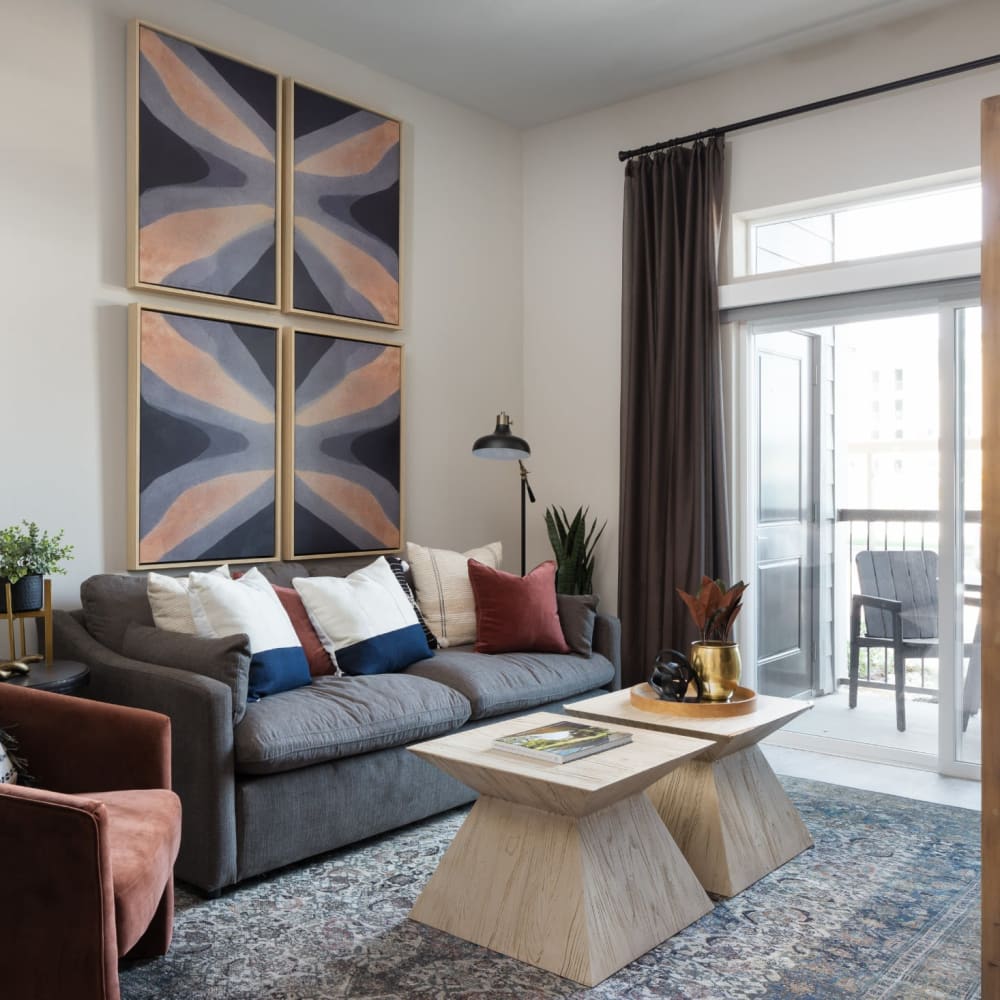 Furnished apartment living room with large area rug and wall art at Bellrock La Frontera in Austin, Texas