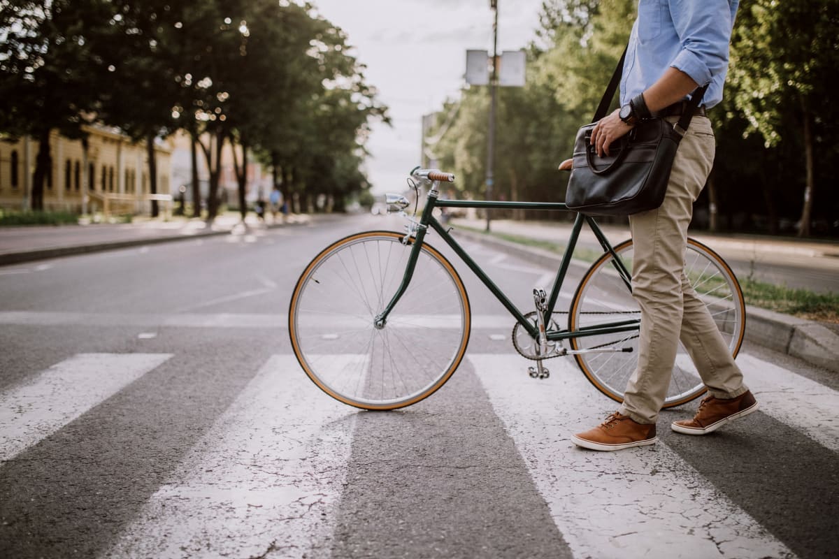 Resident walking his bike in crosswalk in Richardson, Texas from Marquis at Waterview