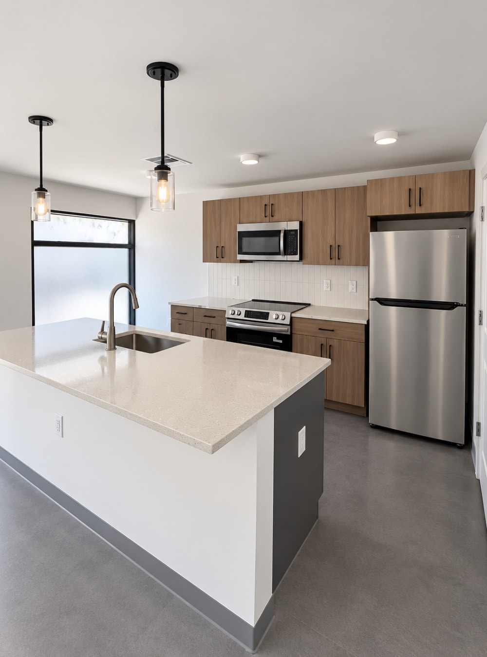 Open-concept kitchen with island sink, wood cabinets, and stainless appliances at Altitude on Main in Richmond, Virginia