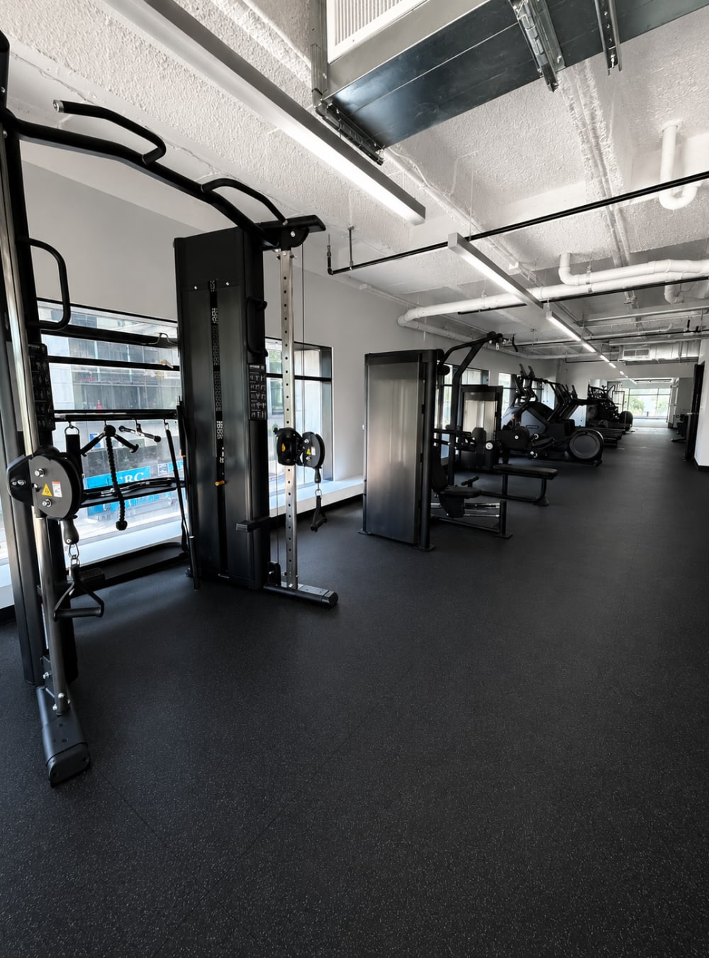 Fitness center with strength training equipment and open workout space at Altitude on Main in Richmond, Virginia