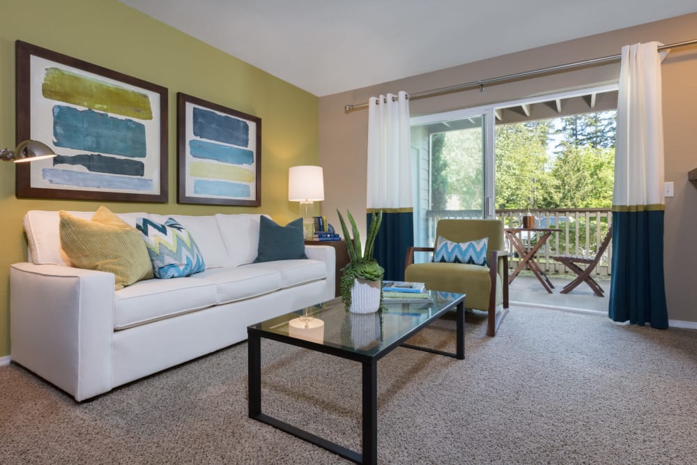Beautifully decorated living space with plush carpeting in the open-concept floor plan of a model home at Timbers at Tualatin in Tualatin, Oregon