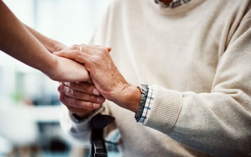 Friendly staff member lending a helping hand to resident at Grand Villa of DeLand in DeLand, Florida