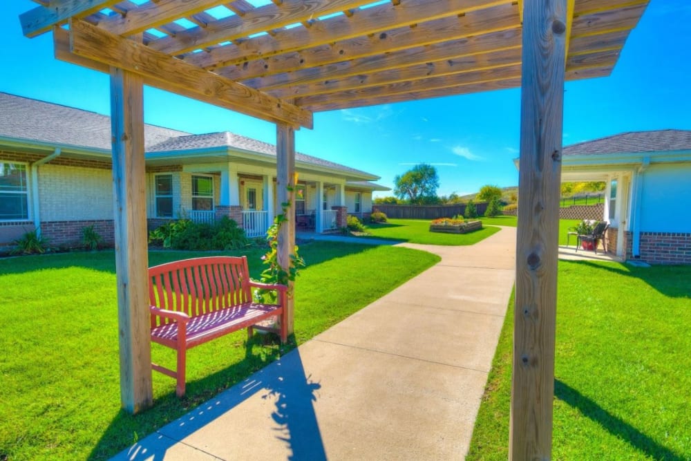Courtyard with green lawns and park bench seating at Addington Place of Fort Madison in Fort Madison, Iowa