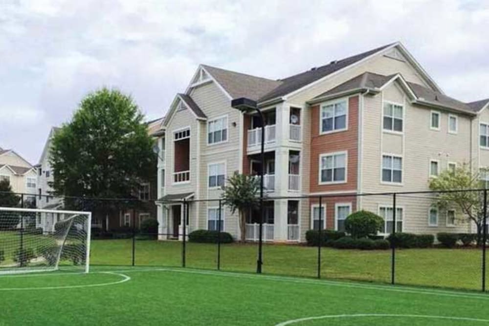 Exterior view of the buildings and soccer field at Belle Vista Apartment Homes in Lithonia, Georgia