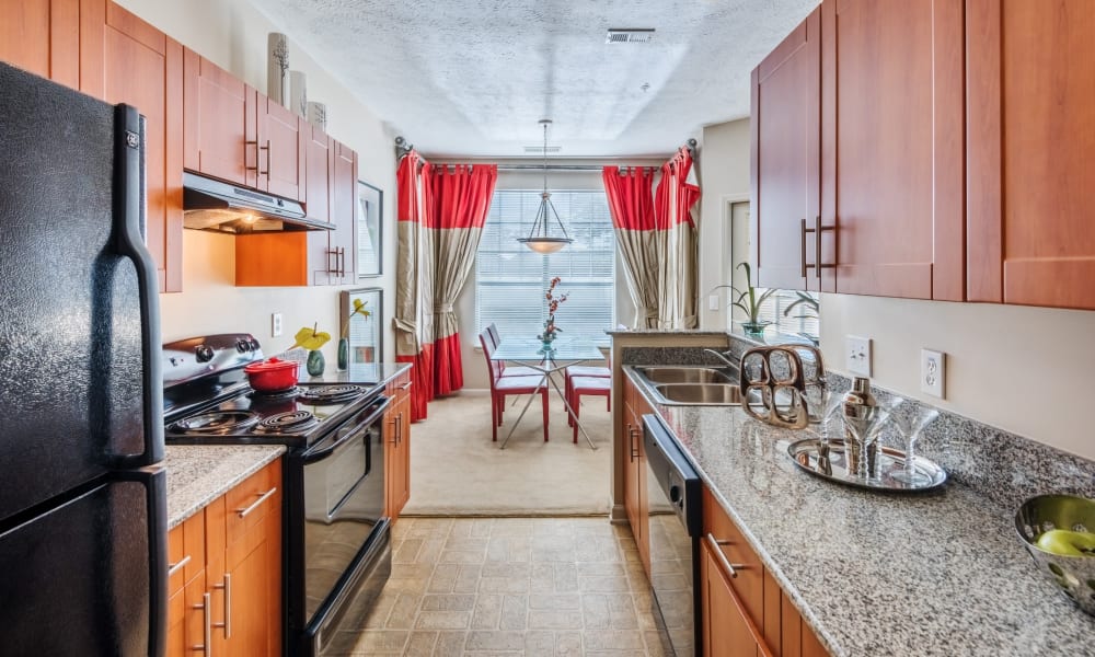 Fully equipped kitchen with black appliances and mahogany cabinets at Westlake at Morganton in Fayetteville, North Carolina