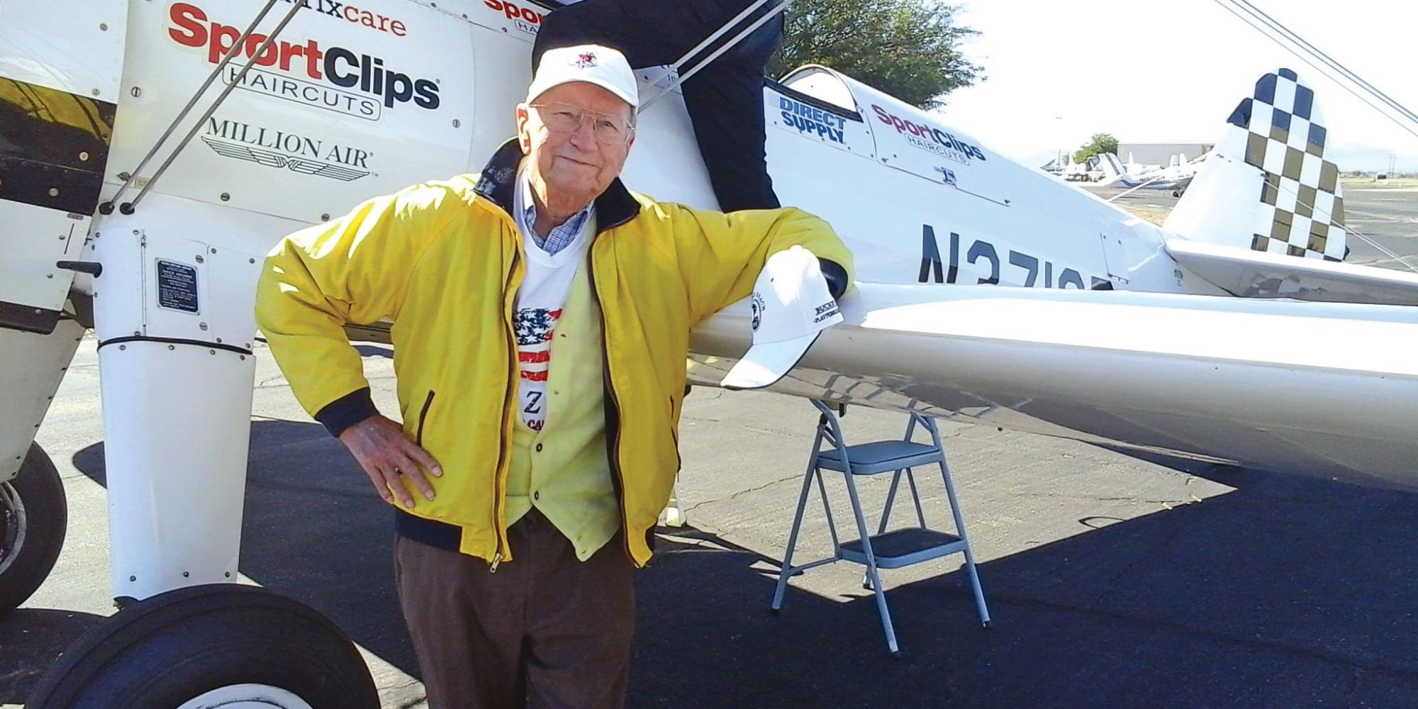 A resident from Williams Place Gracious Retirement Living in Davidson, North Carolina standing next to a plane
