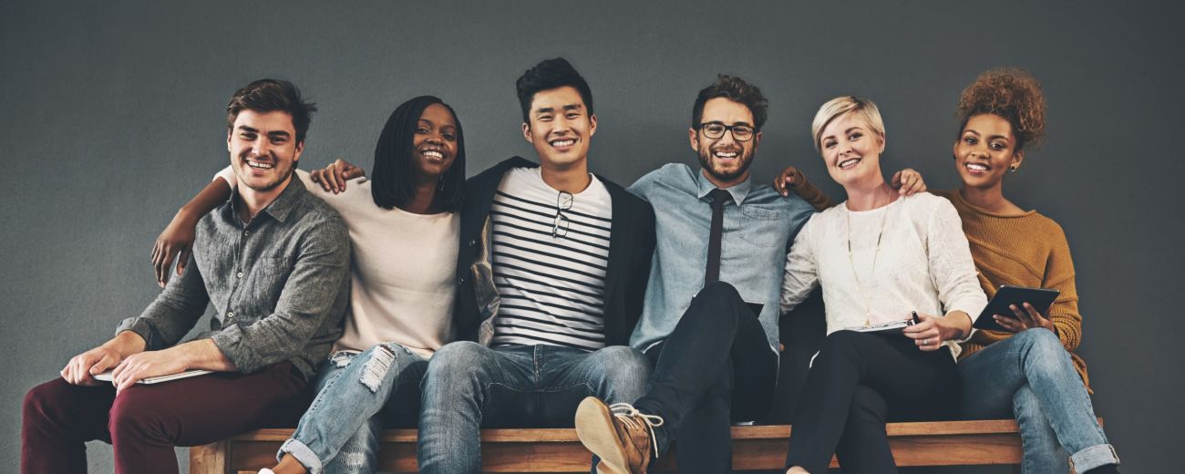 Young professional men and women sitting together on a bench