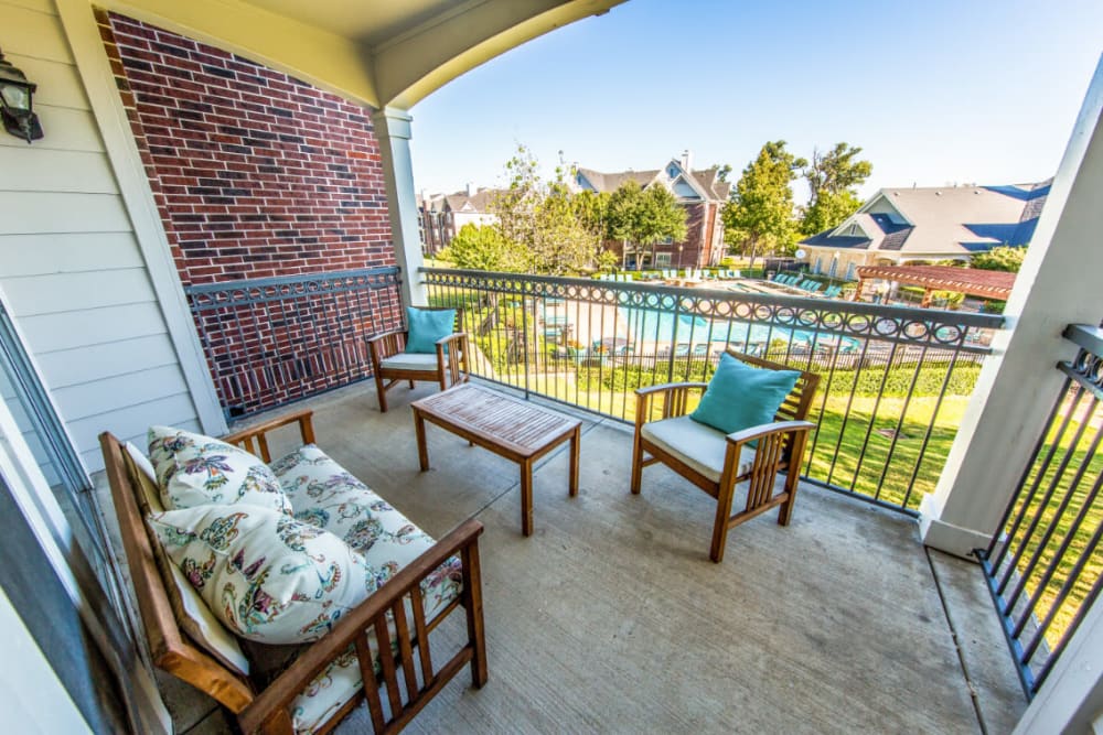 Private balcony with several sitting chairs on second floor overlooking pool deck at Marquis at Silver Oaks in Grapevine, Texas
