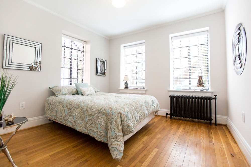 Bedroom with a bed and windows at Historic Boylan Apartments in Raleigh, North Carolina