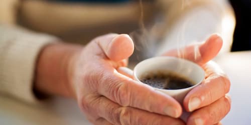 Resident holding cup of coffee at Zion Senior Cottages in Zion, Illinois