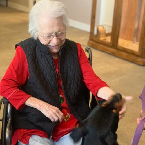 A resident petting a dog at FountainBrook in Midwest City, Oklahoma