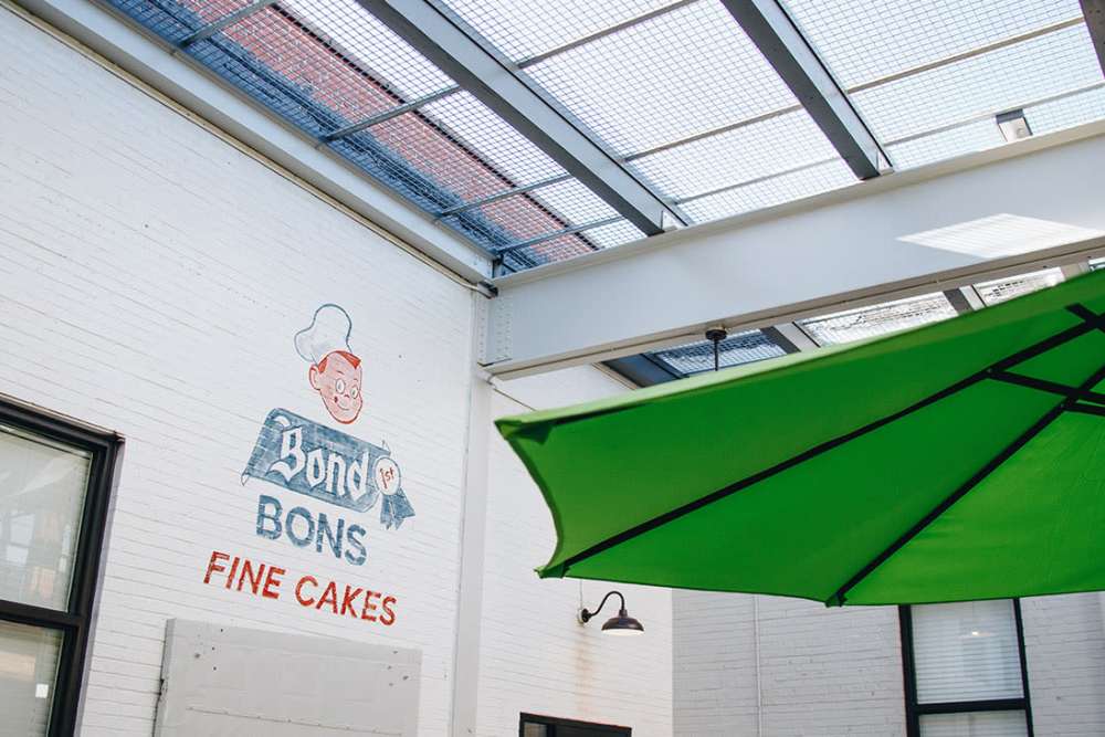 Outdoor seating under green umbrella at Courtyard Lofts at Scott’s Addition in Richmond, Virginia