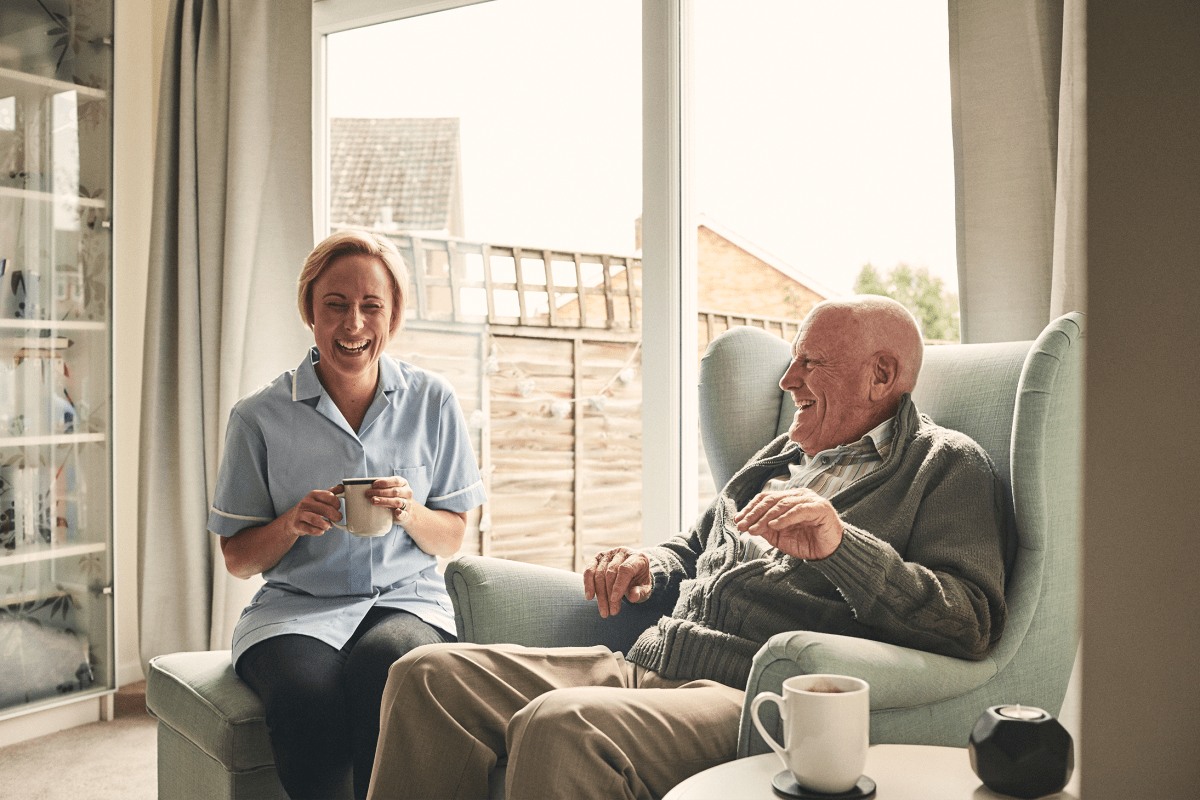 A caregiver having coffee with a resident at Milestone Retirement Communities 