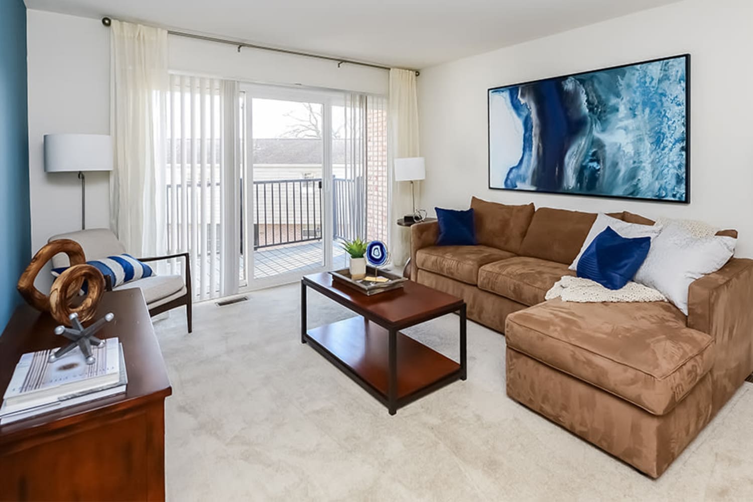 Model living room opening onto a private balcony at Sherry Lake Apartment Homes in Conshohocken, Pennsylvania