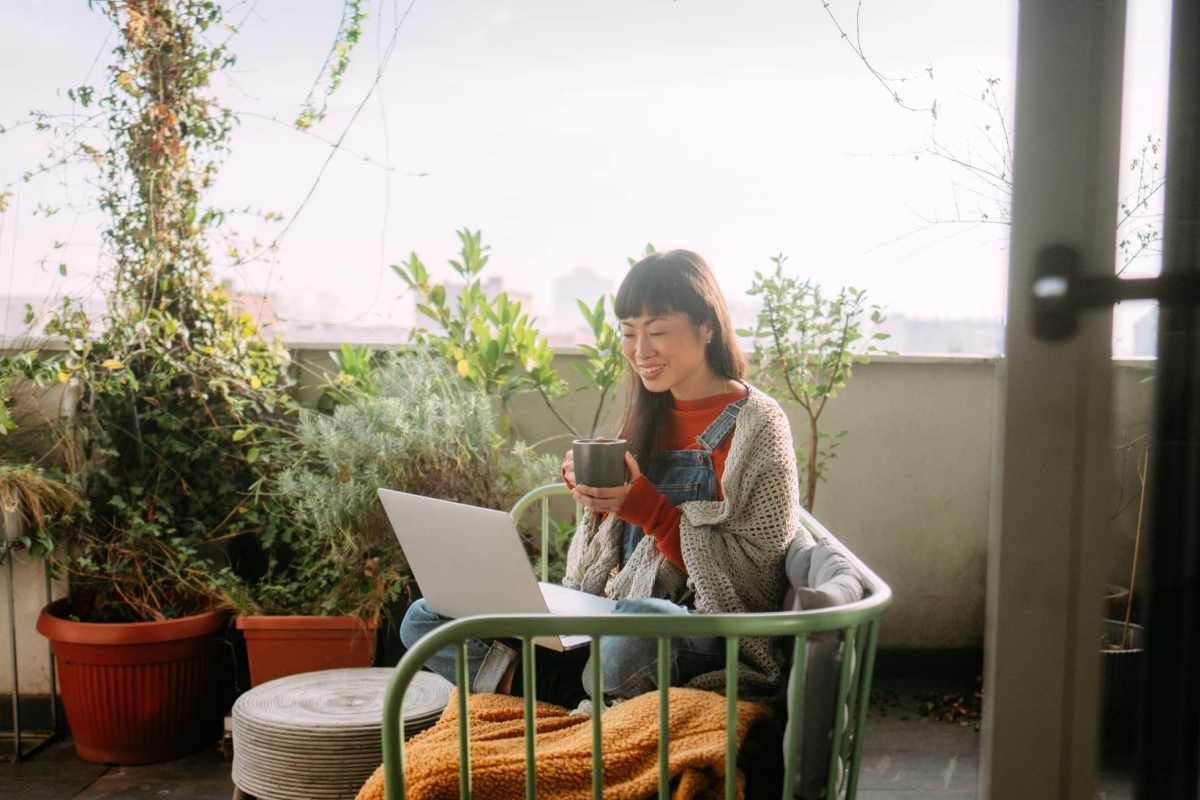 Woman checking laptop while having coffee in baclony at Mayfair Park in Houston, Texas
