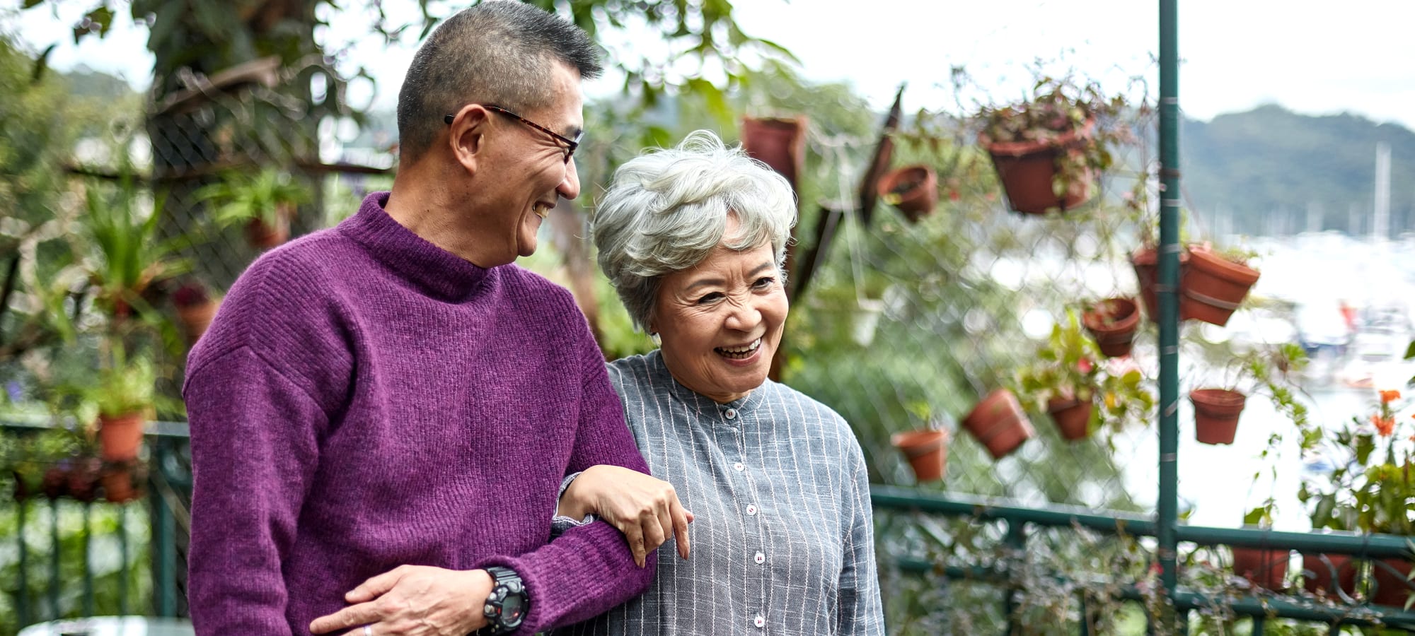 Two elderly people walking outside smiling