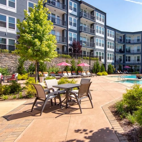Tables and chairs by the pool at Station R Apartments in Atlanta, Georgia