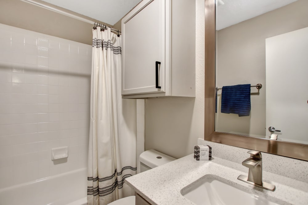 White vanity and spacious bathtubs in the bathroom at Lockhart Apartment Homes in Mesquite, Texas