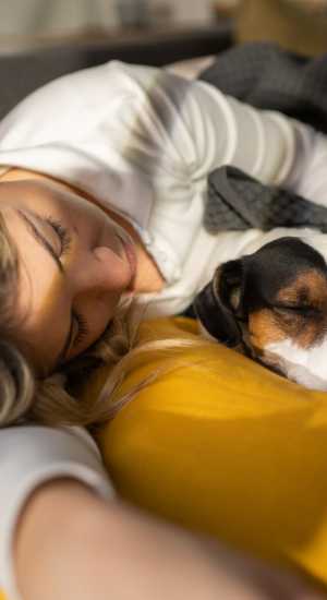 Resident laying with her dog at The Abbey at Barker Cypress in Houston, Texas