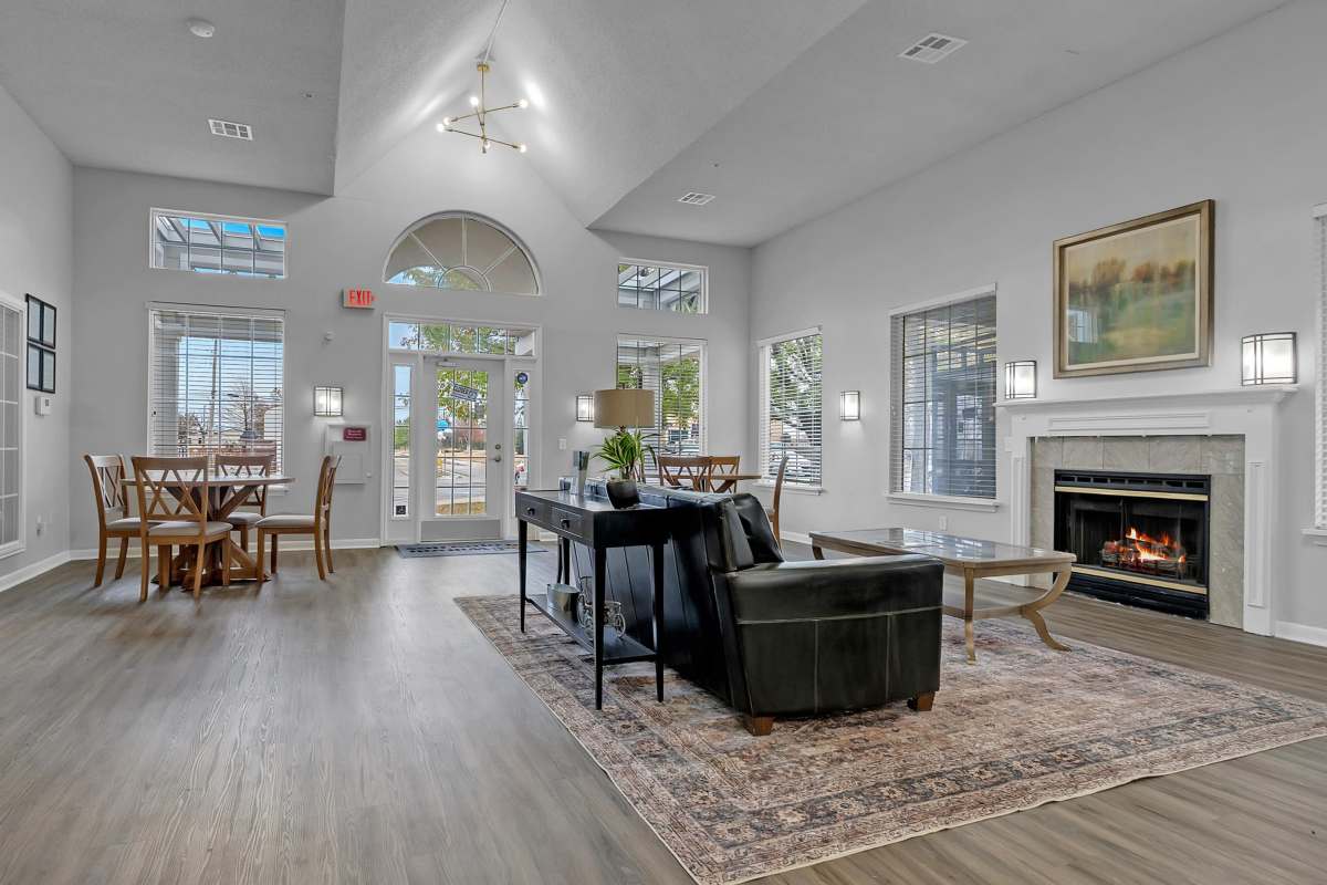 Spacious clubhouse with large couch, coffee table, fireplace and dining area at Garden Courtyards in Tulsa, Oklahoma