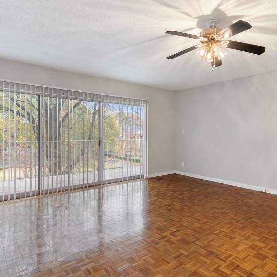 A living room with stylish wooden flooring and access to spacious patio at Central Gardens in Memphis, Tennessee