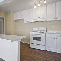 Kitchen with all white color appliance at Tribeca Apartments in Azusa, California