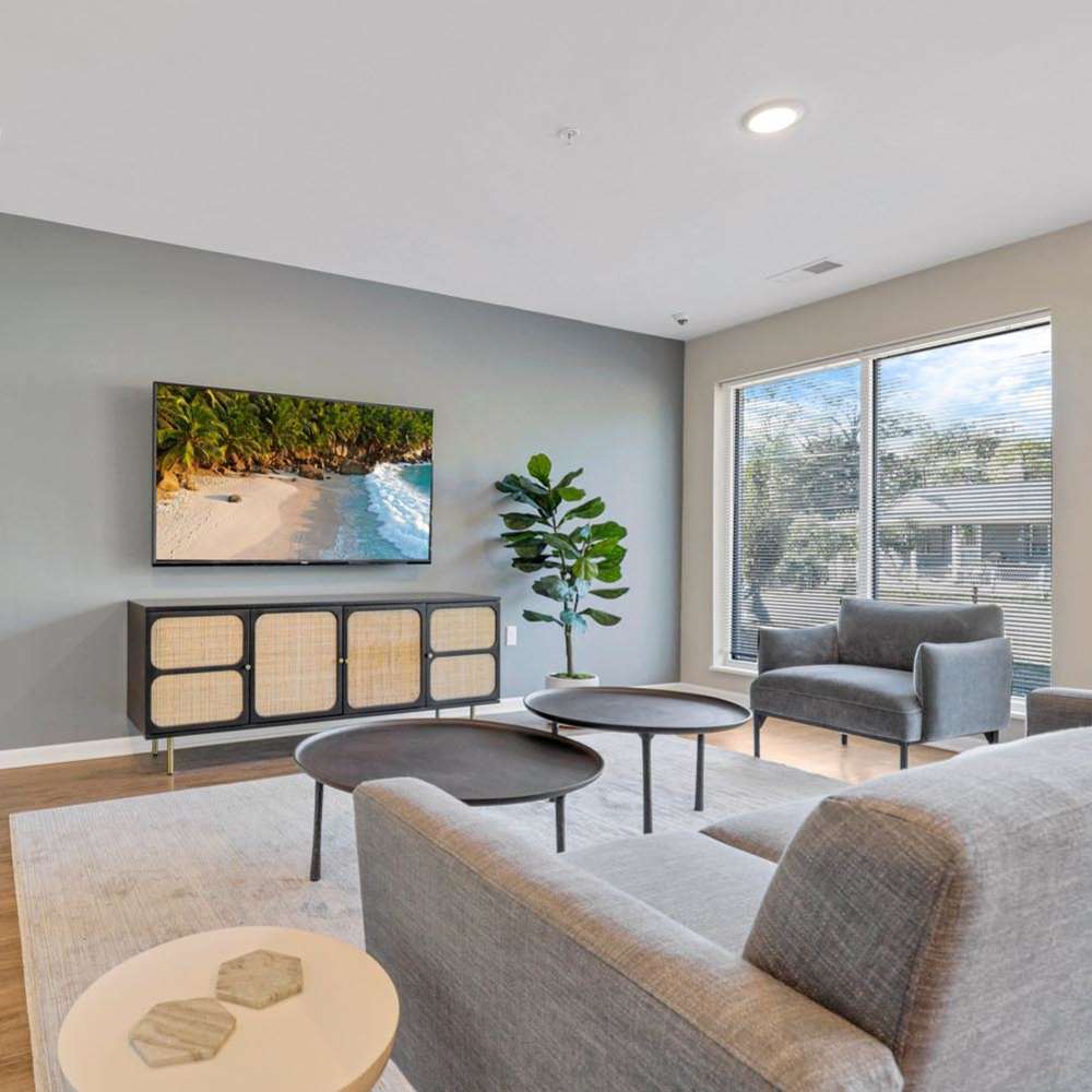 A spacious living room with couch and chairs with a wall mounted television at Lockbourne Greene in Columbus, Ohio