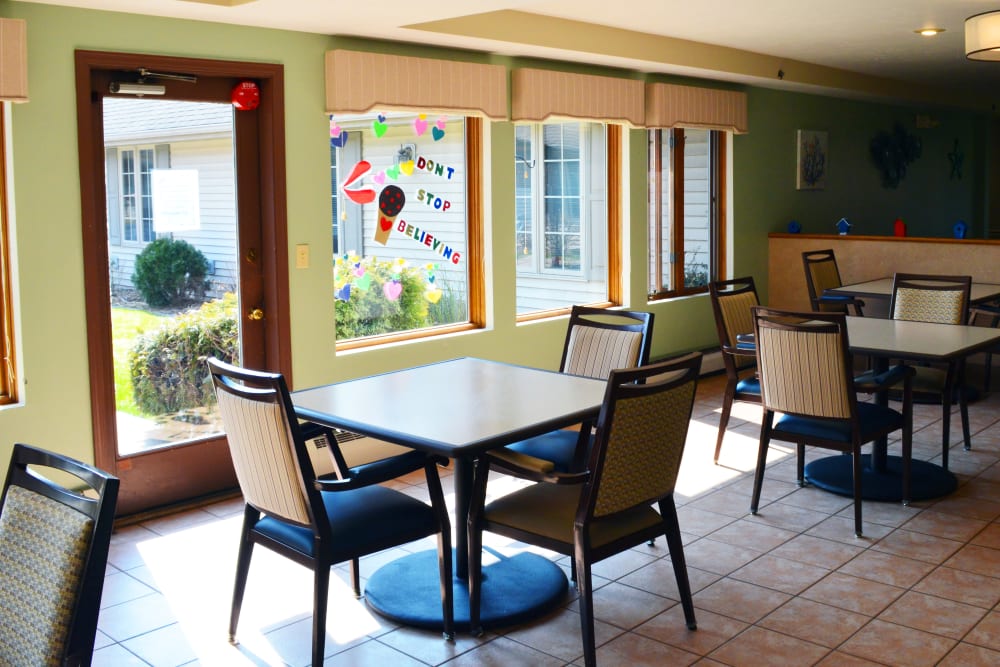 A communal dining area with good sunlight at Wyndemere Memory Care in Green Bay, Wisconsin. 