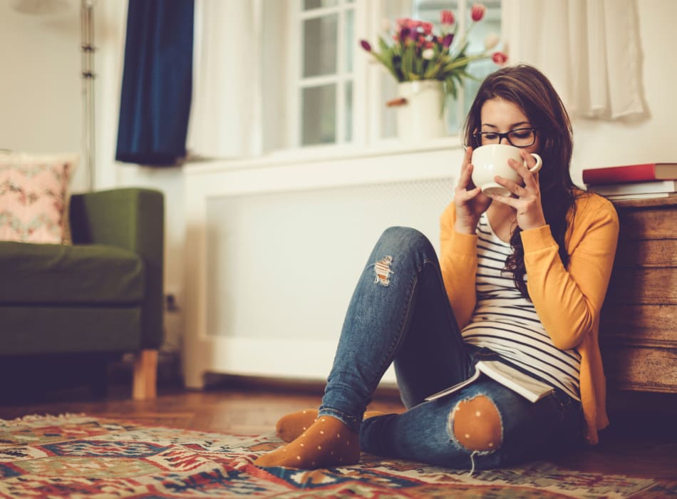 Resident relaxing with a cup of tea in her new home at Sofi Westview in San Diego, California