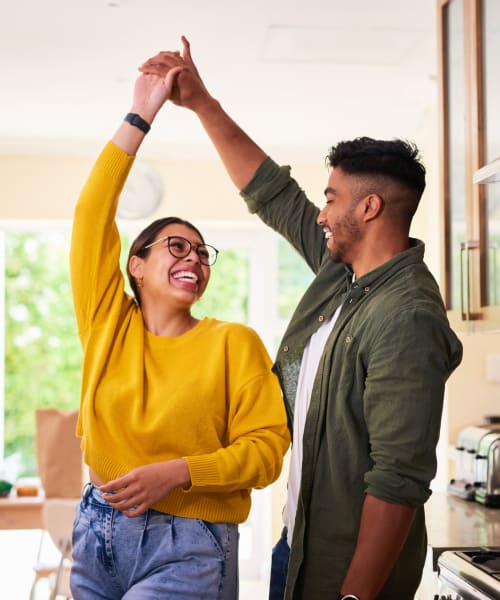 A man and woman dancing in a kitchen at Claremont Towers in Hillsborough, New Jersey