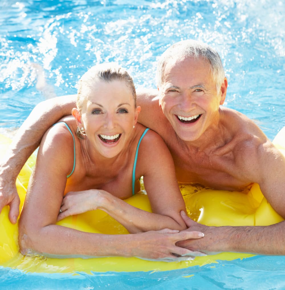 Resident couple enjoying the pool and sunshine at Blossom Collection in Rochester, Michigan