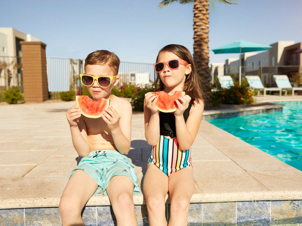 Two young residents eating watermelon by the pool at BB Living at Val Vista in Gilbert, Arizona