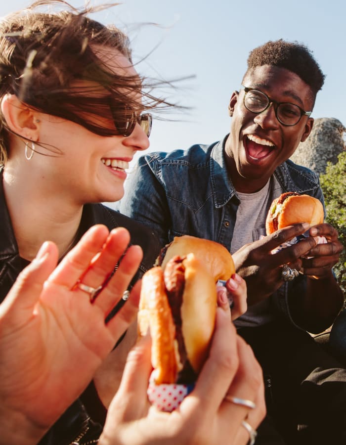 Student friends enjoying delicious hamburgers outside on a beautiful day near 20 Hawley in Binghamton, New York