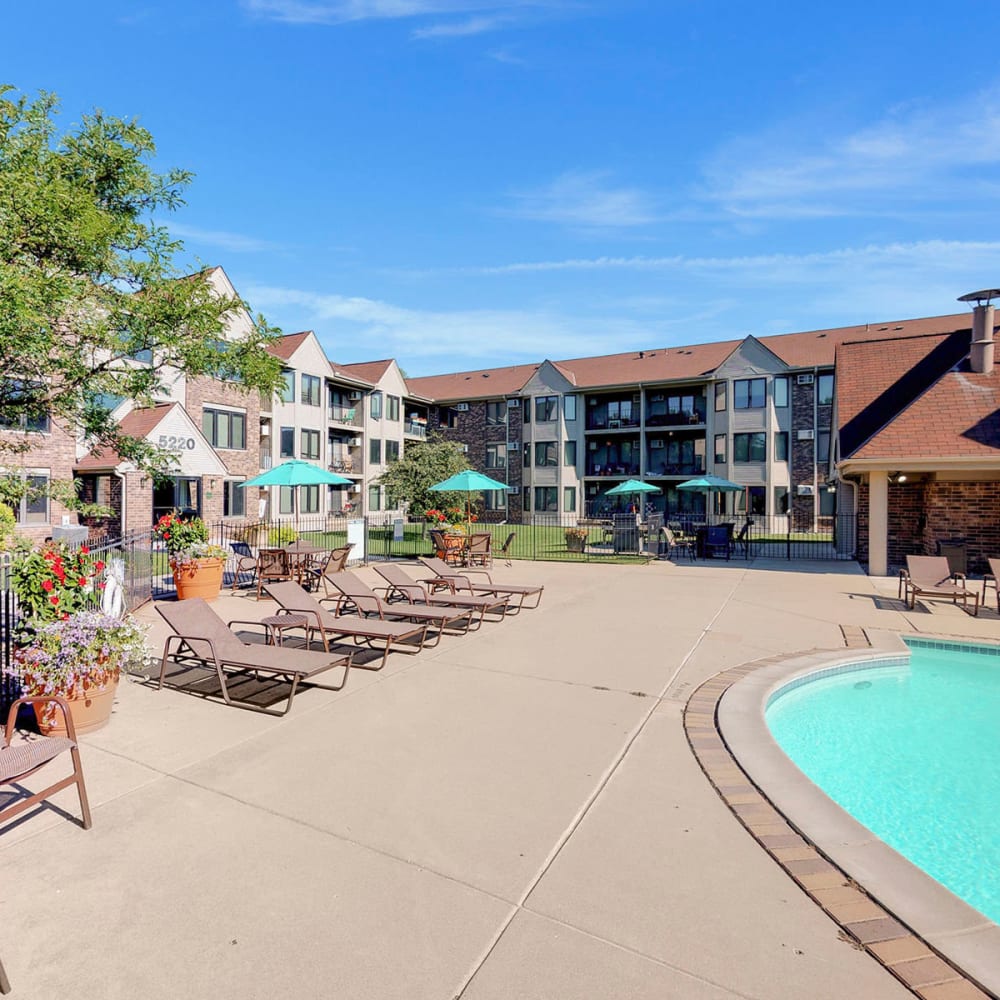 Lounge chairs near the pool on a beautiful day at Oaks Lincoln Apartments & Townhomes in Edina, Minnesota