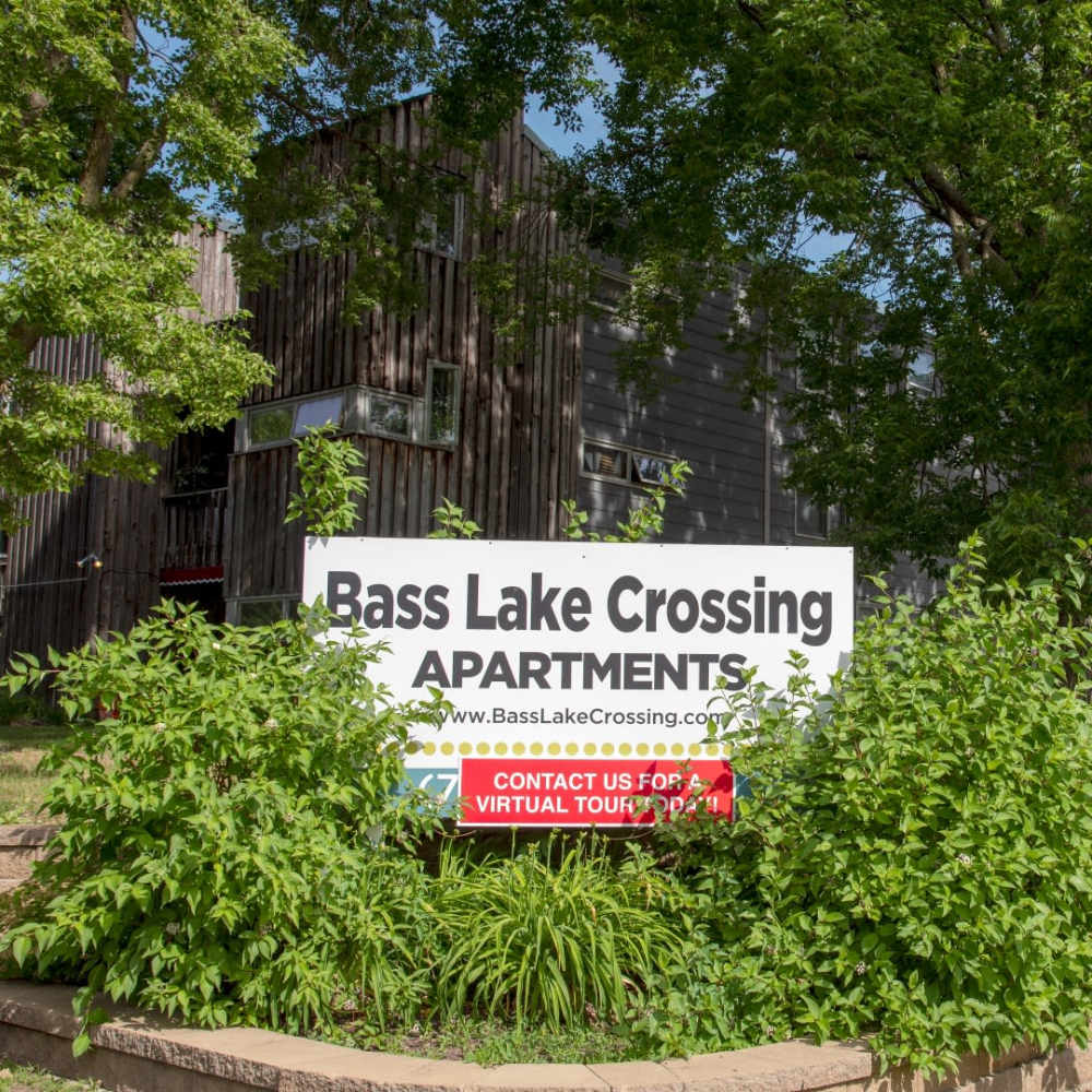 A signboard reading bass lake crossing apartments near Bass Lake Crossing in New Hope, Minnesota