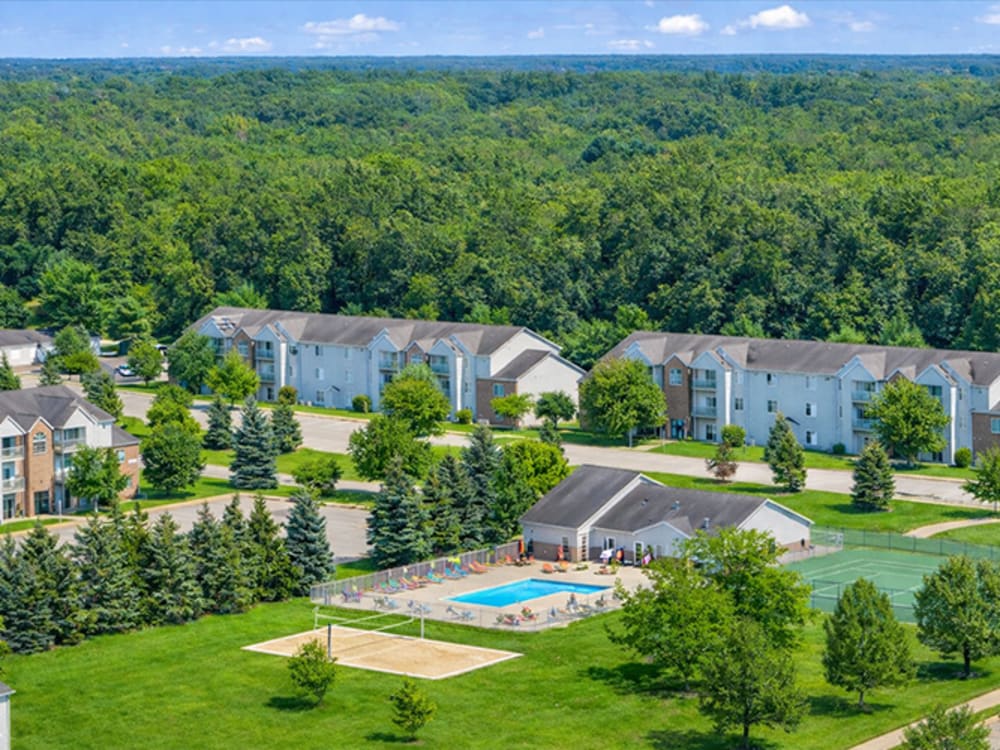 Resort-style pool surrounded by green landscaping at Somerset Park Apartments in Bath, Michigan