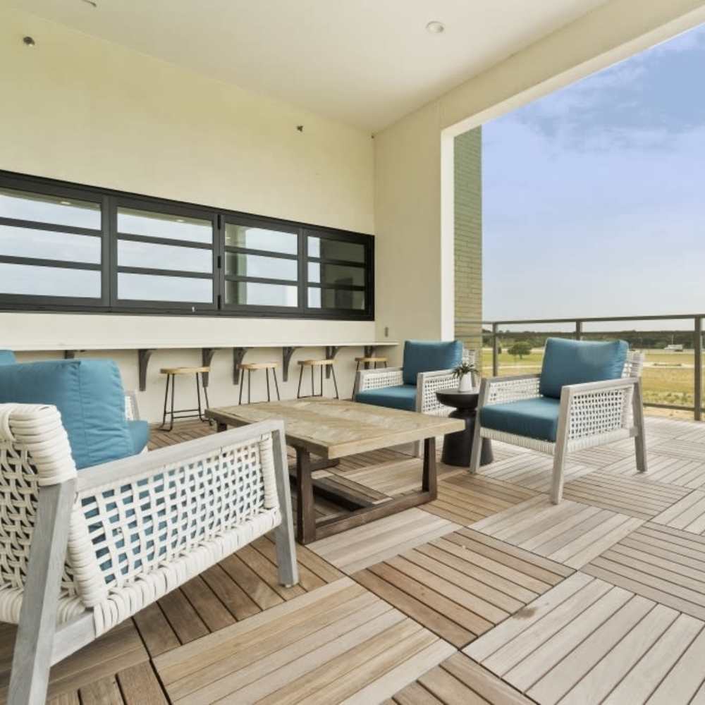 Common seating are with couch, chairs, table and barstool at Millennium Place in Corinth, Texas