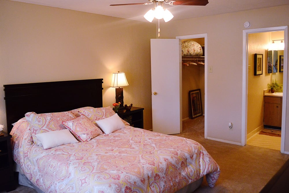 An apartment bedroom with a walk-in closet and bathroom at Villa Bella in Euless, Texas
