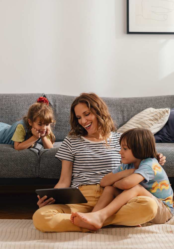 Happy resident with her kids in living room at Dunbar Apartments in Lexington, North Carolina
