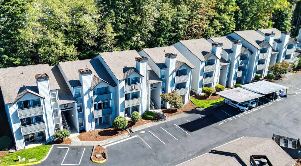 View of the community with cars parked in front of the buildings at Crosspointe Apartments in Federal Way, Washington