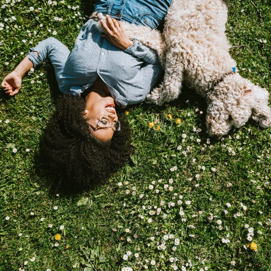 Dog and owner laying in the grass at Admiral's Way in Norfolk, Virginia