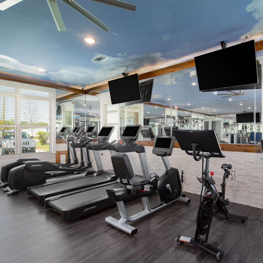 Fitness center with equipment and flat TV screens at Retreat at Redstone in Crestview, Florida