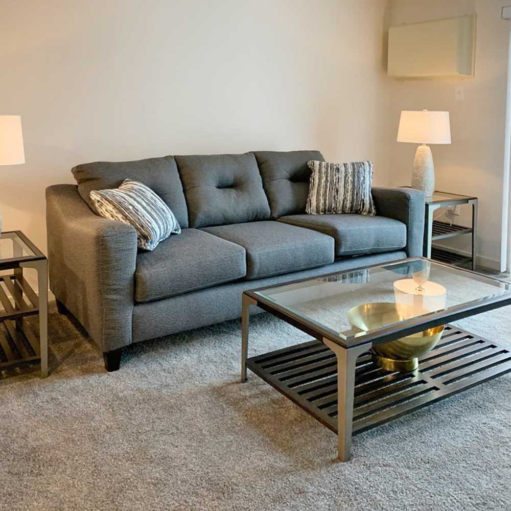 Spacious living room with large couch, coffee table and side lamp at Depot on Main in Zimmerman, Minnesota