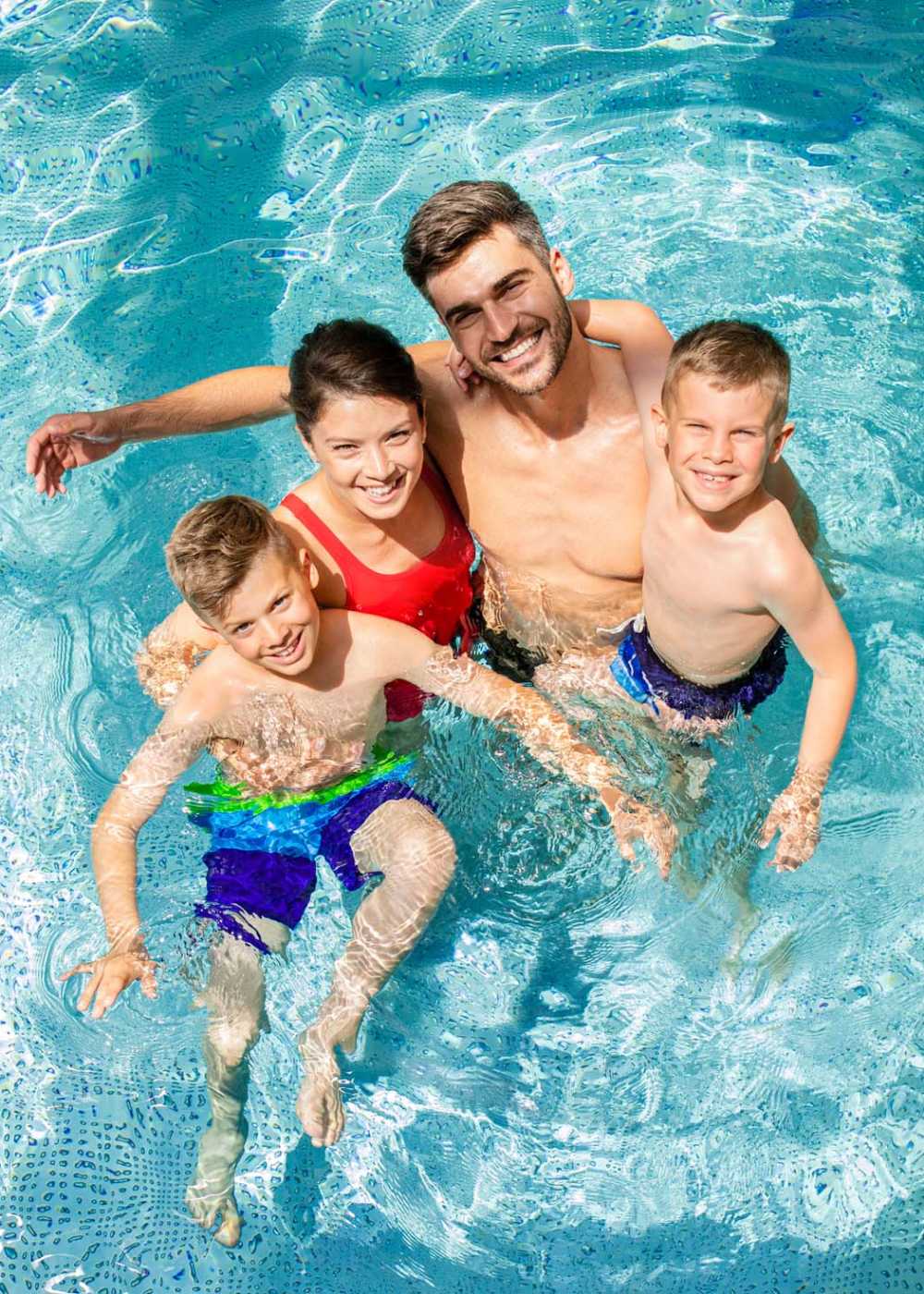 Resident family enjoying in the swimming pool at Cypress Creek Montfort Drive in Dallas, Texas