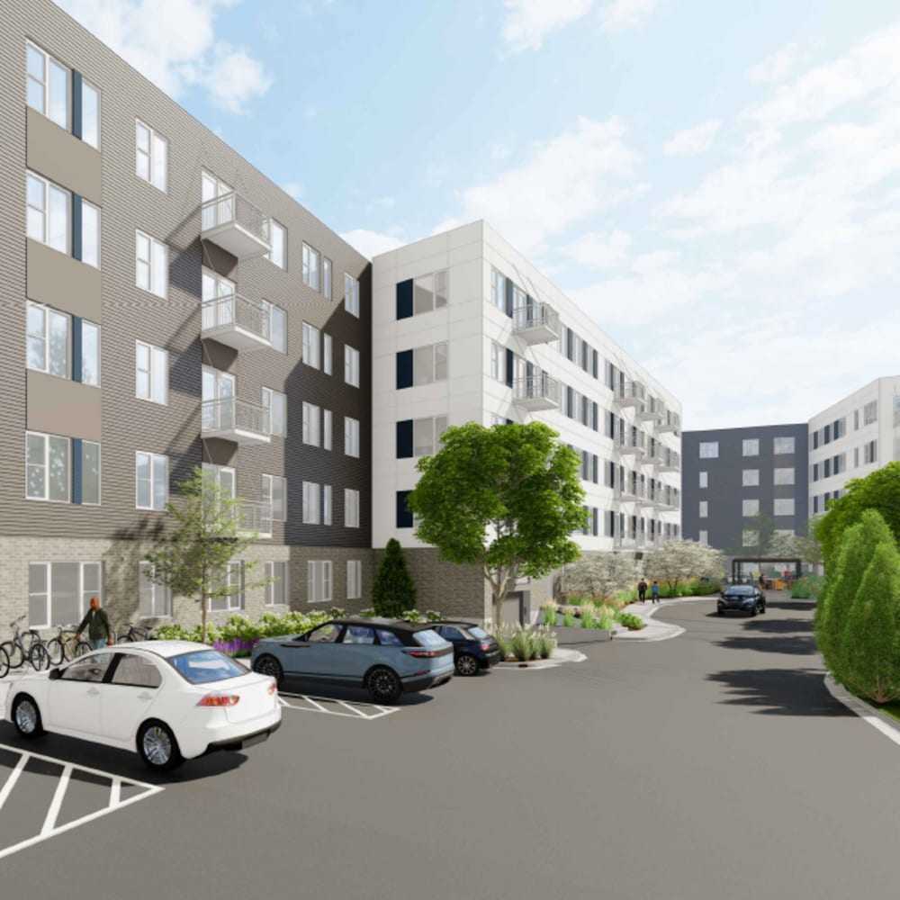 Apartment building with mixed facades, front parking area, bicycles, and landscaped garden at The Intersect in Madison, Wisconsin 