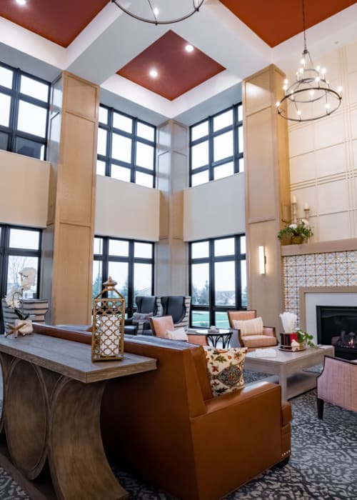 Cozy resident lounge area with armchairs and fireplace at The Pillars of Lakeville in Lakeville, Minnesota