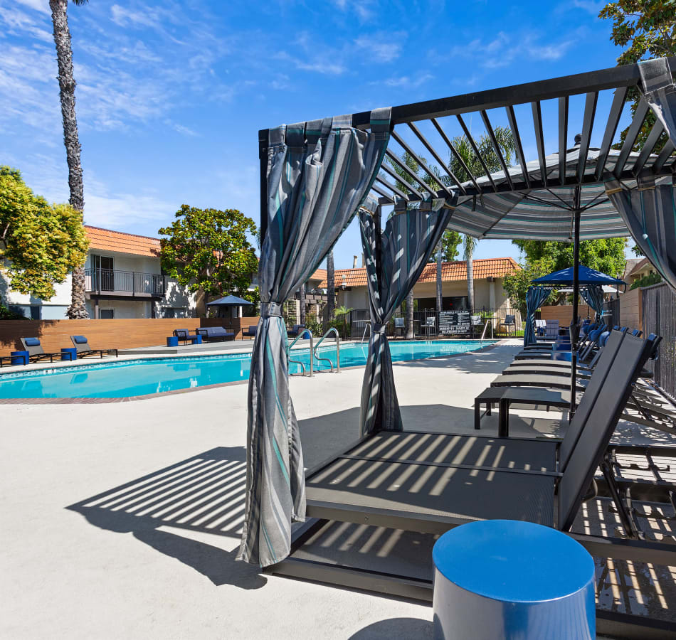 Shaded pool furniture alongside the large swimming pool on a warm sunny day at Terra Camarillo in Camarillo, California