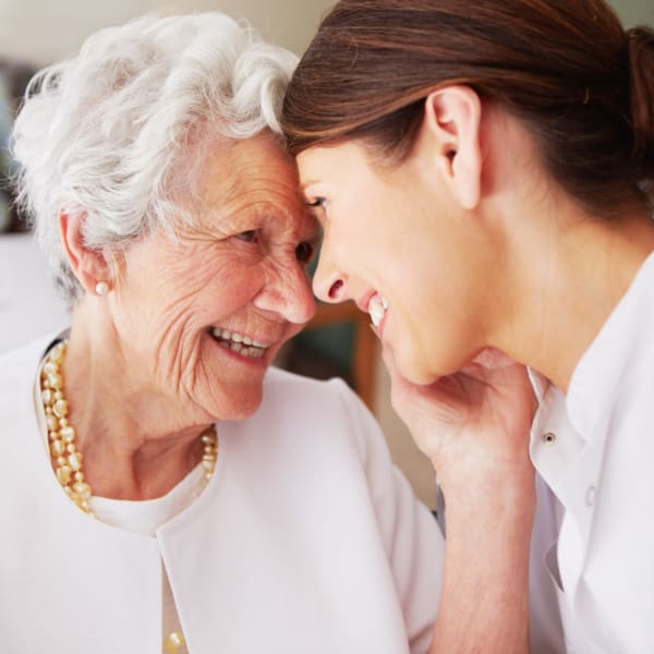 Resident smiling while embracing her daughter at Pacifica Senior Living Ellensburg in Ellensburg, Washington.