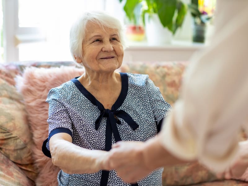 A resident holding hands with a team member at Reflections at Garden Place in Columbia, Illinois. 